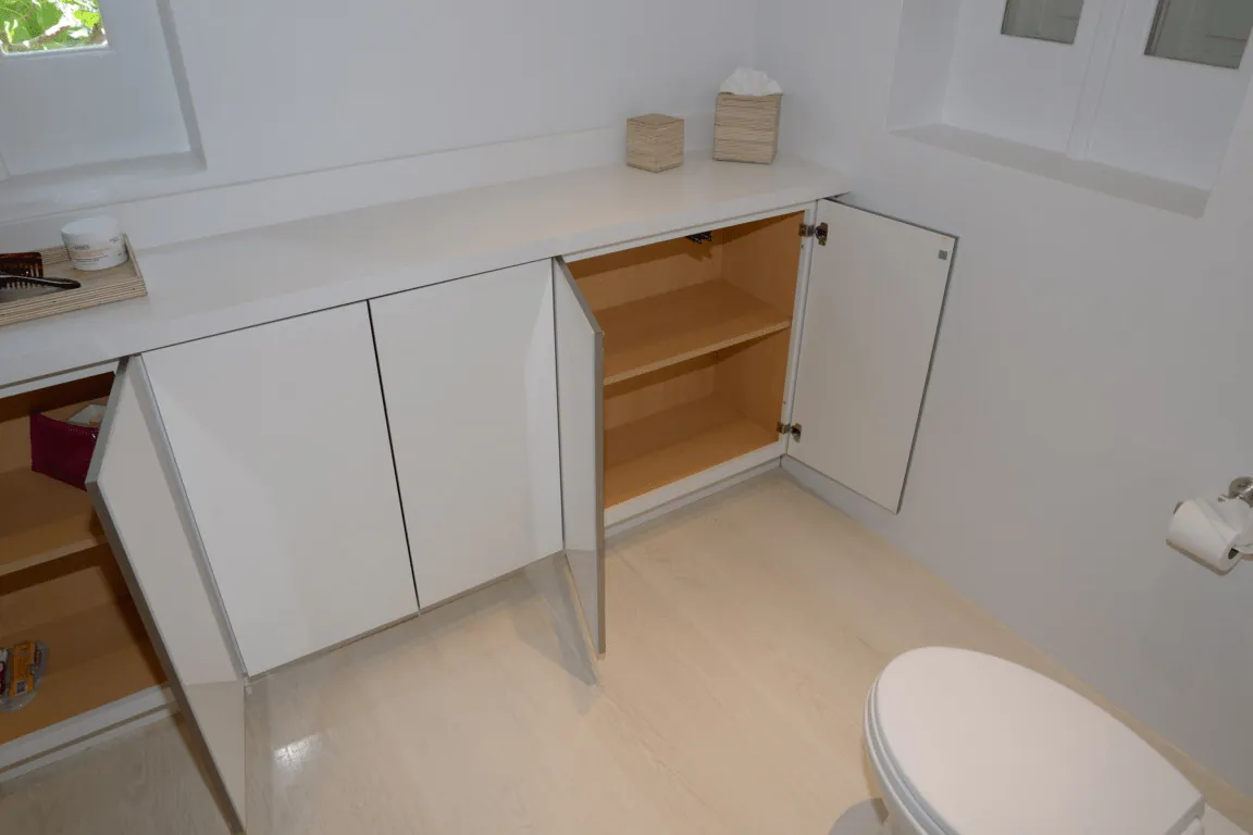 White bathroom vanity cabinets and countertop in a renovated bathroom