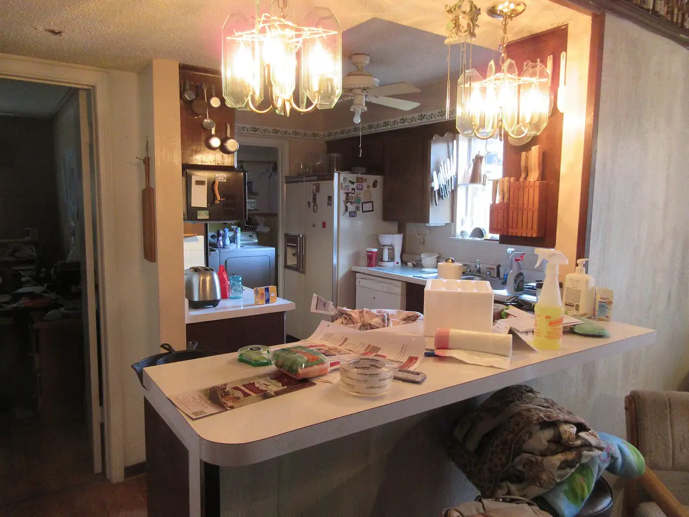 Cluttered older kitchen counter before renovation