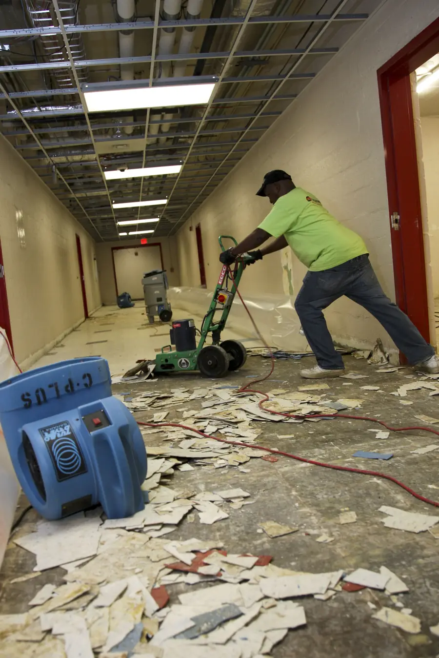 Worker removing old tiles during a renovation stage
